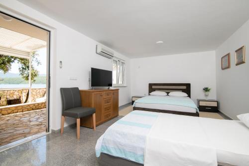 a bedroom with two beds and a television at Apartments Lukrecia in Neum