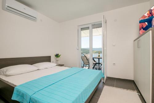 a bedroom with a bed and a balcony with a table at Apartments Lukrecia in Neum