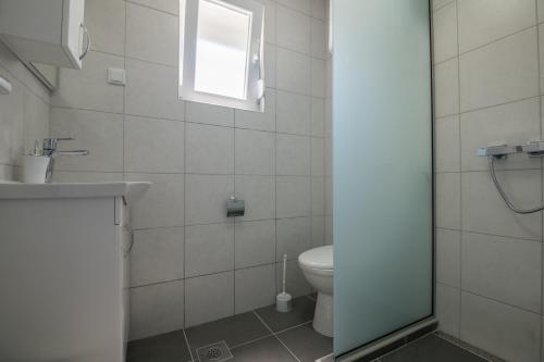 a bathroom with a toilet and a window at Apartments Lukrecia in Neum
