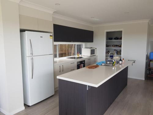 a kitchen with white appliances and a white refrigerator at Hampton Homestay in Palmview