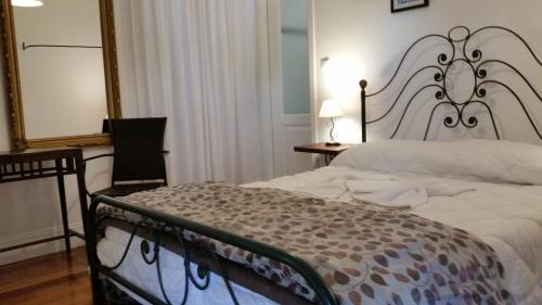 a bedroom with a large bed and a mirror at Nossa Casa na Aldeia in Viseu
