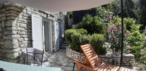 a patio with a table and a chair and a building at Les Villas de Qeparo in Qeparo
