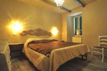 - une chambre avec un lit doté d'une tête de lit en bois dans l'établissement appartamento di classe nel castello di Panicale, à Panicale
