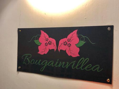 a sign for a restaurant with pink butterflies on it at Bougainvillea in Guwahati