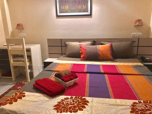 a bedroom with a bed with a colorful rug on it at Bougainvillea in Guwahati