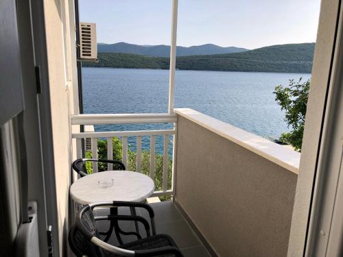 a balcony with a table and chairs and a view of a lake at Apartments Lukrecia in Neum