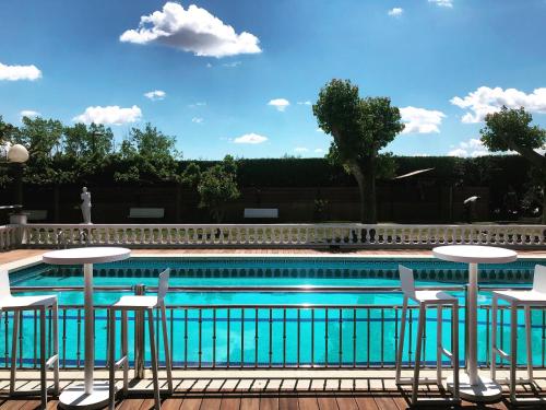 - une piscine bordée de tables et de chaises dans l'établissement Hotel & Restaurant Figueres Parc, à Figueres