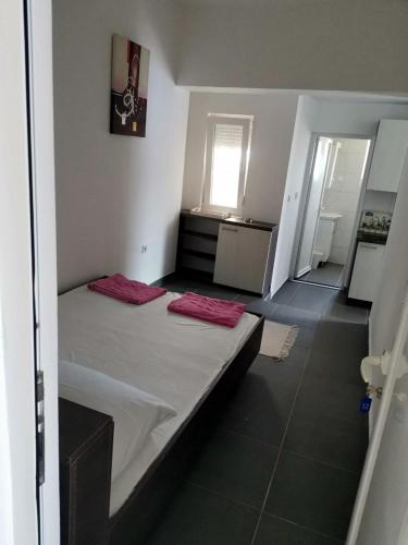 a room with a bed with two red pillows on it at Apartments Lukrecia in Neum