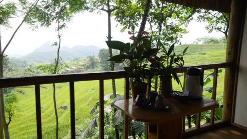 a balcony with a table and a view of a field at Puluong Home in Pu Luong