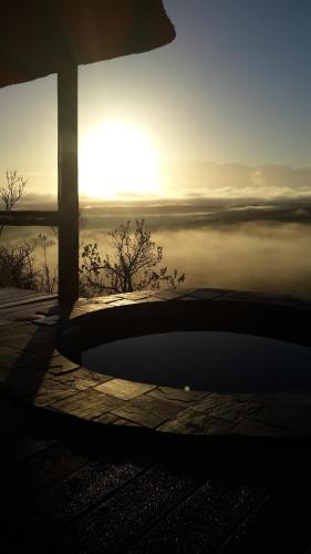 a view of the sunset from a building with a view of the water at Leopard Mountain Safari Lodge in Manyoni Private Game Reserve