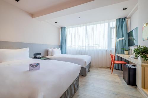 a hotel room with two beds and a desk at PACE HOTEL Suzhou Guanqian Branch in Suzhou