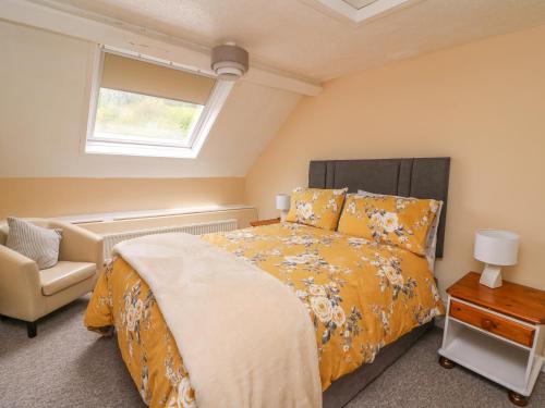 une chambre avec un lit, une fenêtre et une chaise dans l'établissement Penlone Cottage, à Rhayader