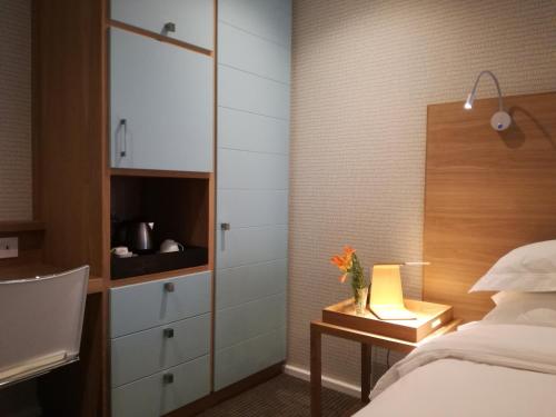 a bedroom with a bed and a desk with a lamp at Ocean Vista Boutique Guest House in Durban