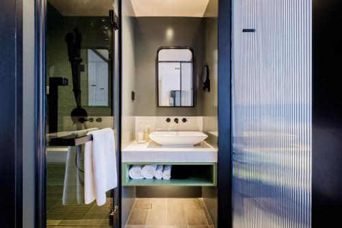 a bathroom with a sink and a mirror at PACE HOTEL Suzhou Guanqian Branch in Suzhou