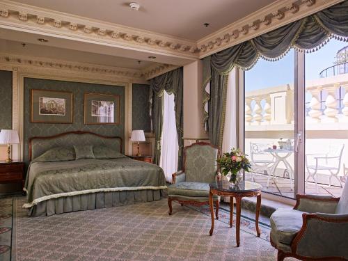 a bedroom with a bed and a balcony at Grand Hotel Wien in Vienna