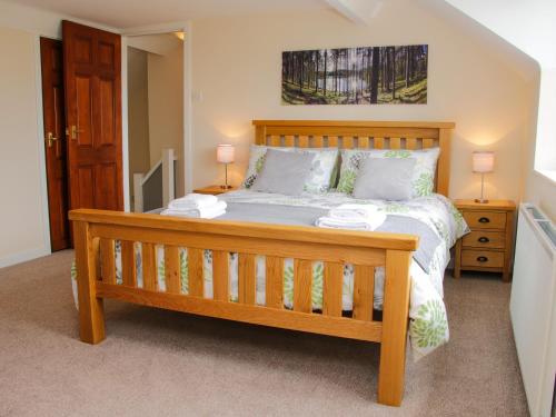 a bedroom with a wooden bed with two lamps at Caesamson in Caersws