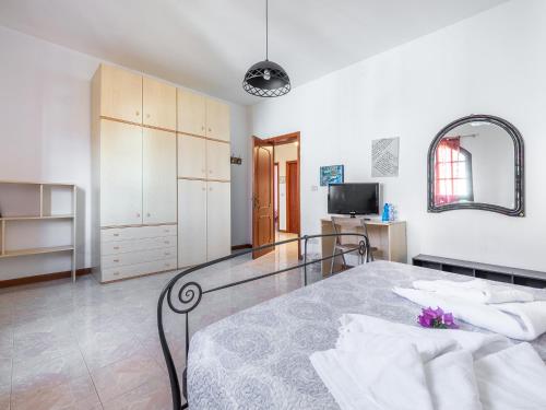 duża biała sypialnia z łóżkiem i lustrem w obiekcie Il Giardino dell'Arte w mieście Capoterra