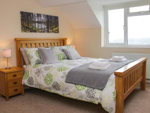 a bedroom with a bed with two towels on it at Caesamson in Caersws