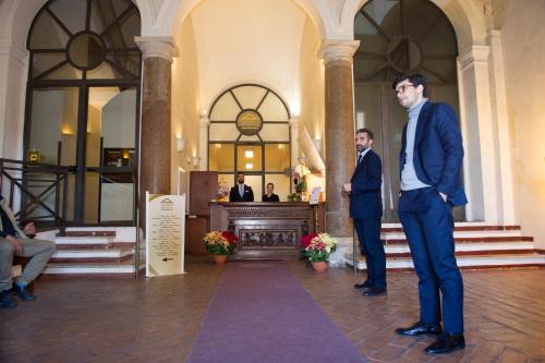Due uomini in giacca e cravatta in piedi in una hall di Domus Sessoriana a Roma