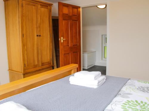a bedroom with a bed and a wooden cabinet at Caesamson in Caersws