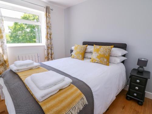 a bedroom with a white bed with pillows and a window at Owl Cottage in Llandrindod Wells