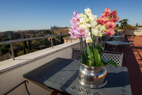 a vase of flowers on a table on a balcony at Domus Sessoriana in Rome