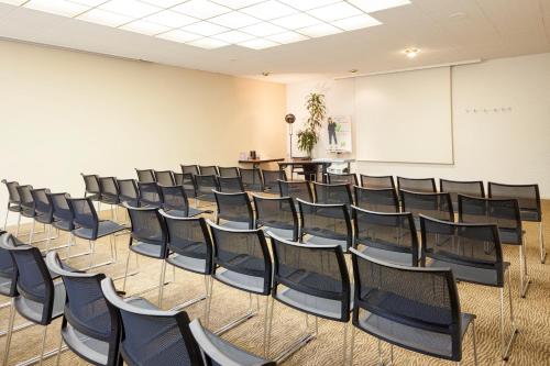 an empty room with chairs and a whiteboard at ibis Styles Besançon in Besançon