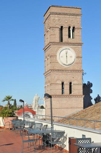 a clock tower with tables and chairs in front of it at Domus Sessoriana in Rome