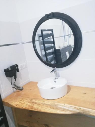 a mirror sitting on top of a wooden table at Logis Auberge de Pont Calleck in Inguiniel
