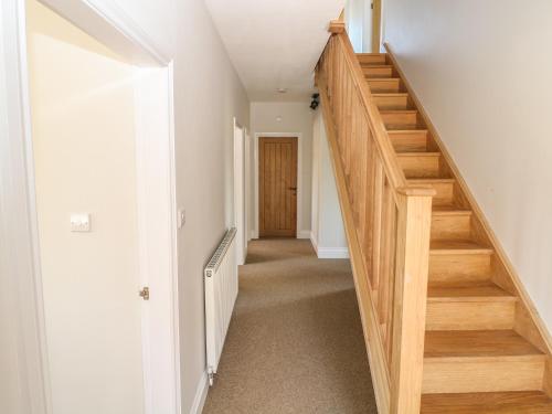 a hallway with wooden stairs in a house at Highcroft in Belper