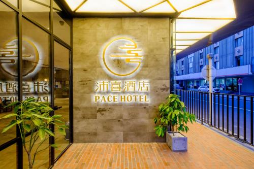 a building with a large hotel sign on the side of it at PACE HOTEL Suzhou Guanqian Branch in Suzhou