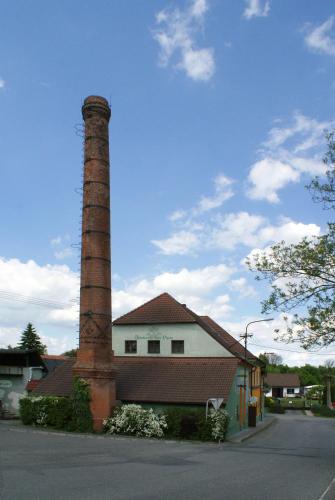 a building with a brick chimney next to a house at Pivovarský dvůr Lipan in Týn nad Vltavou