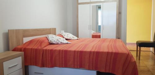 a bed with a red blanket and two pillows on it at Clara 2 in Poreč