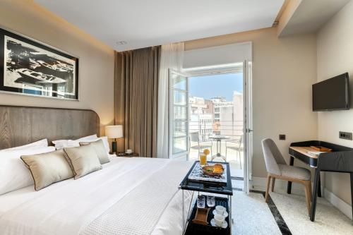 a bedroom with a bed and a desk and a window at Athenian Foss in Athens
