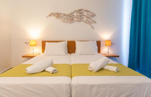 a bedroom with a large bed with two pillows at Iris Skiathos in Skiathos Town