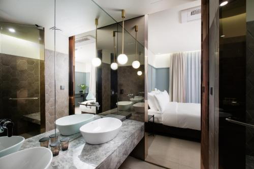 uma casa de banho com 2 lavatórios e uma cama em Park Marine Hotel em Incheon