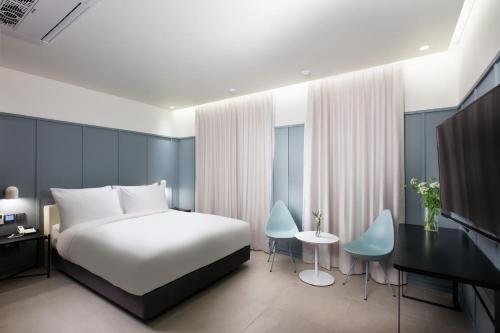 a bedroom with a bed and a table and chairs at Park Marine Hotel in Incheon