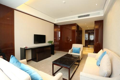 a living room with a couch and a tv at Days Hotel by Wyndham Shanxi Xinzhou in Xinzhou