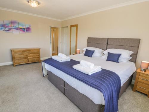 1 dormitorio con 1 cama grande con sábanas azules y blancas en Gwelfor, en Talsarnau