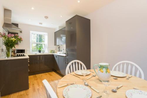 a kitchen and dining room with a wooden table and chairs at 7-11 Kings Park in Bicester