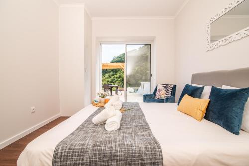 a bedroom with a large bed with two teddy bears on it at Casa do Outeiro with Heated Pool 30C in Povoação