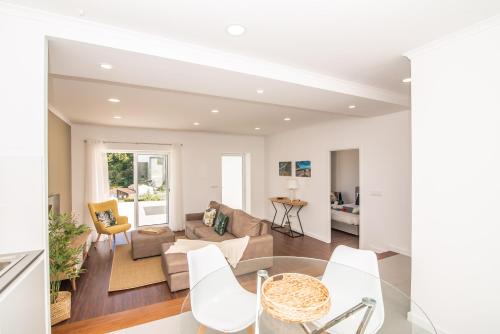 a living room with a glass table and white chairs at Casa do Outeiro with Heated Pool 30C in Povoação