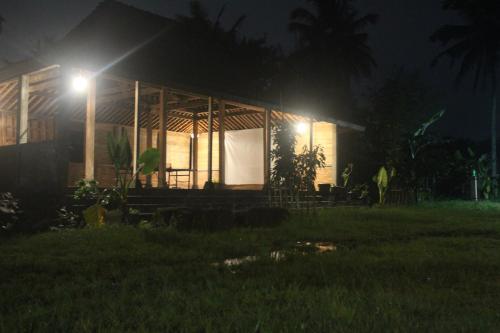 a house lit up at night with lights at JOGLO Greenhouse in Ngemplak