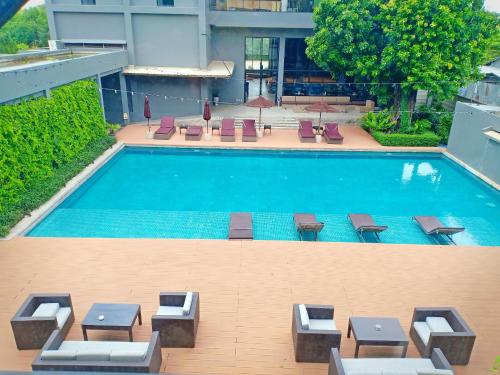 an overhead view of a swimming pool with tables and chairs at Vismaya Suvarnabhumi Hotel in Lat Krabang