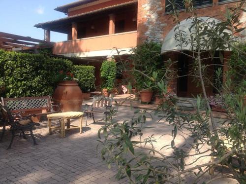 a patio with chairs and a table and a building at Agriturismo Settepassi Tuscany in Ponte Buggianese