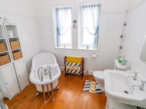 un bagno con due lavandini, un water e una finestra di Castle School House a Kidwelly