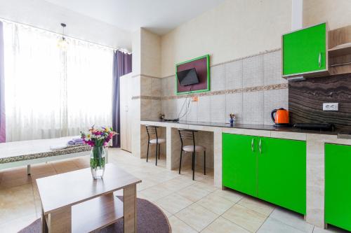 a kitchen with green cabinets and a table with flowers at Dream Apartments in Kyiv