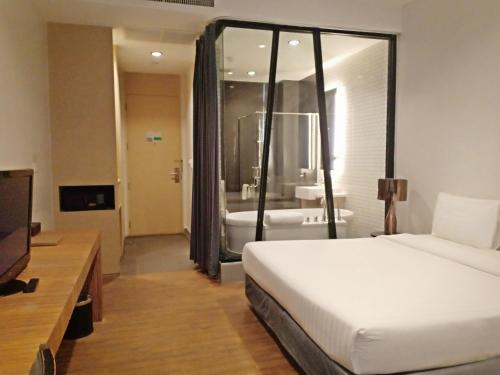 a hotel room with a bed and a bathroom at Vismaya Suvarnabhumi Hotel in Lat Krabang