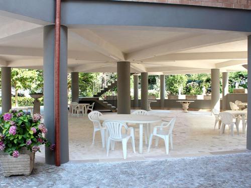 a patio with white tables and chairs and flowers at Oasi di Pace in Sutri