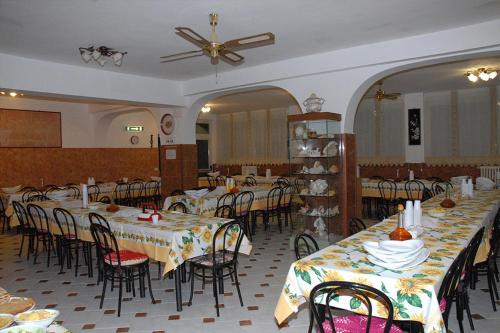 une salle à manger avec des tables et des chaises et un ventilateur de plafond dans l'établissement Oasi di Pace, à Sutri